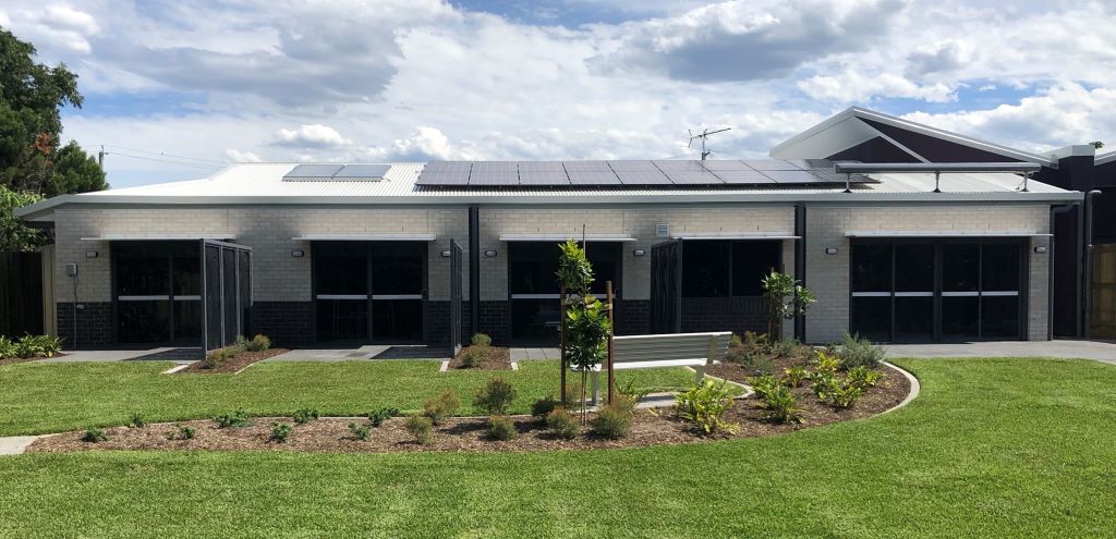 Picture of Marsden SDA home High Physical Support. Back of home, three bedroom doors open onto the backyard. To the right large glass doors showing the living area and it's access into the yard.